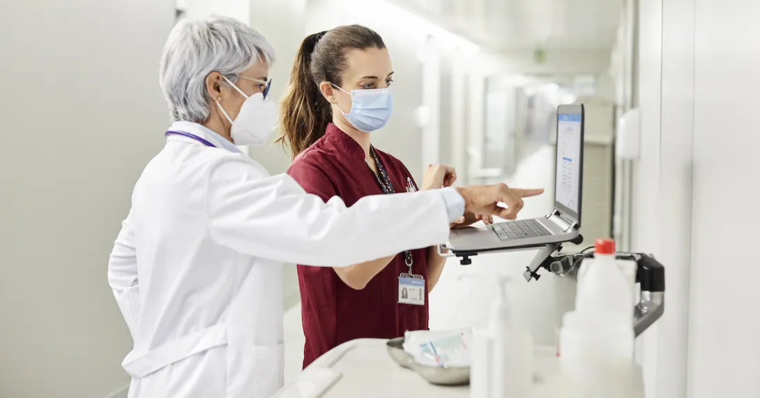 A doctor and a nurse using a laptop in a hospital. A doctor and a nurse using a laptop in a hospital.