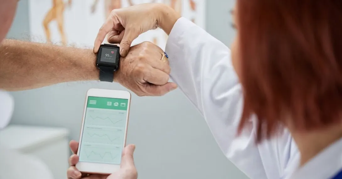 Doctor showing senior patient how to synchronize health app in smartphone and smartwatch Doctor showing senior patient how to synchronize health app in smartphone and smartwatch