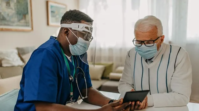 Patient in mask with healthcare worker in PPE