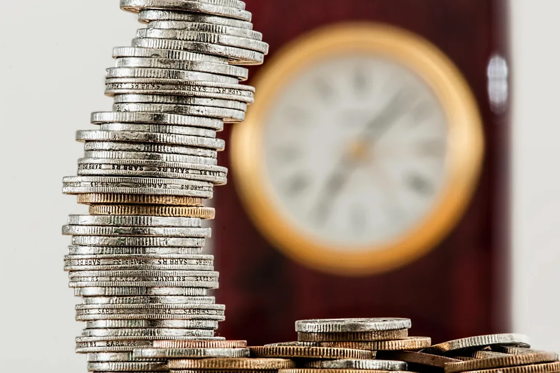 Coins with a clock in the background.