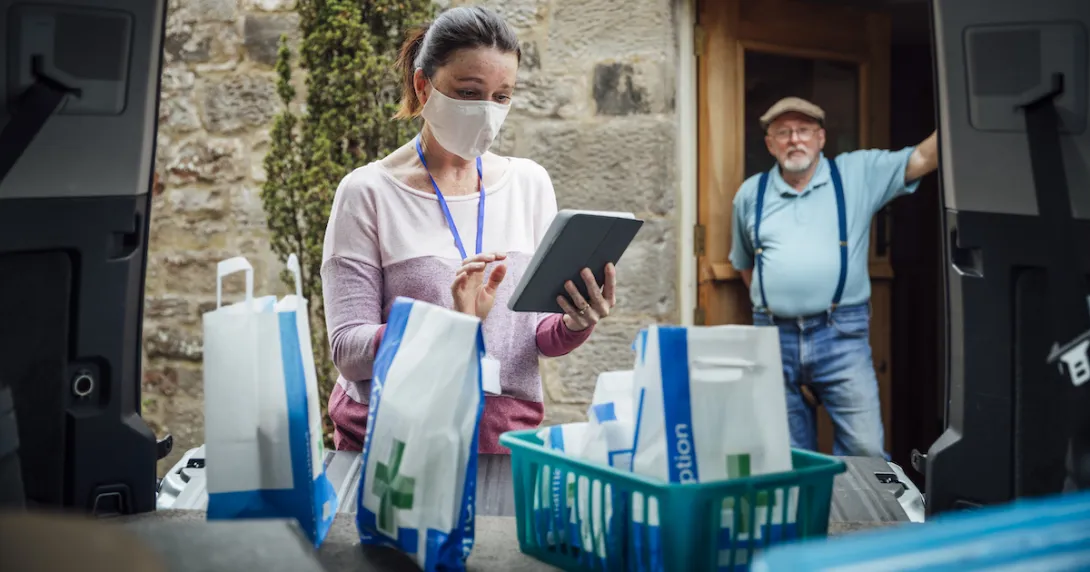 A man waiting in a doorway as a woman delivers medications A man waiting in a doorway as a woman delivers medications