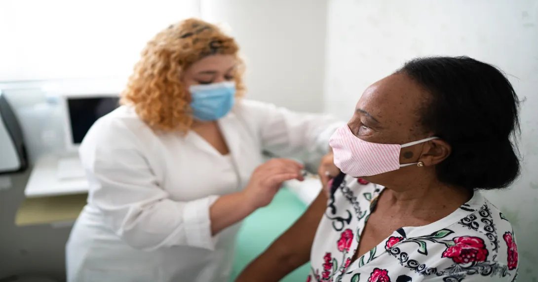 A healthcare provider administering a vaccine. A healthcare provider administering a vaccine.