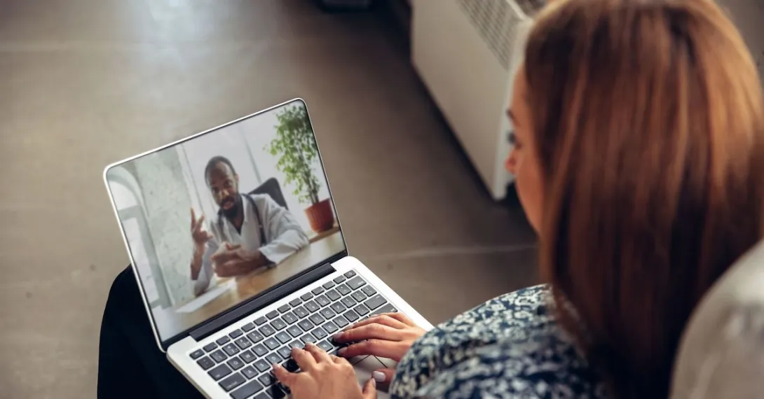 A woman talking to a doctor through a video chat on her laptop A woman talking to a doctor through a video chat on her laptop