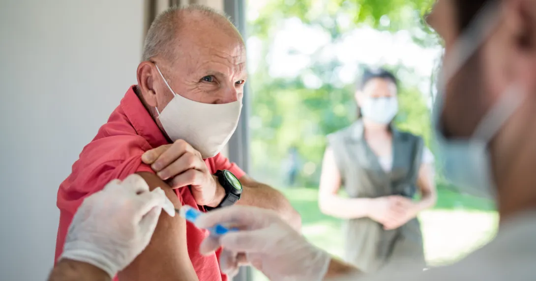 An older man getting a vaccine. An older man getting a vaccine.