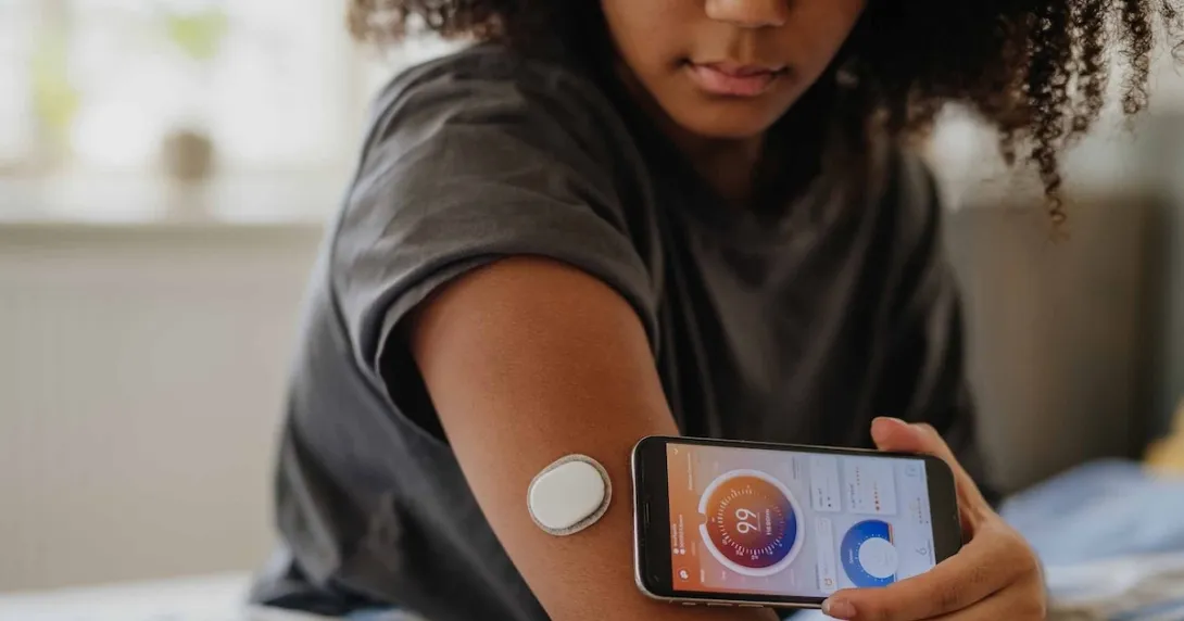 Woman with a CGM and smart phone Woman with a CGM and smart phone