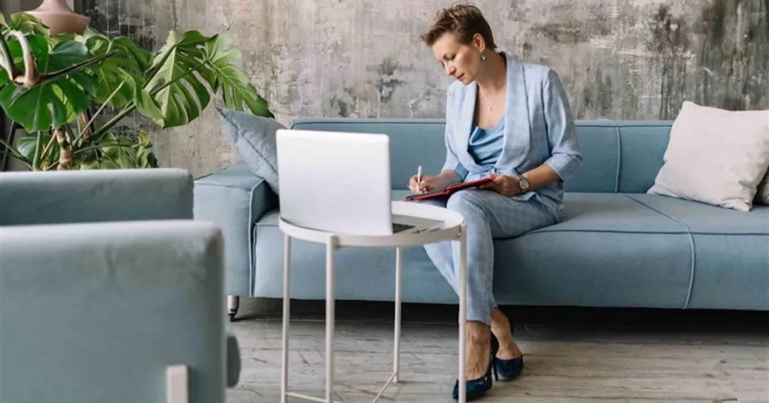 Person sitting on a couch while looking at a computer