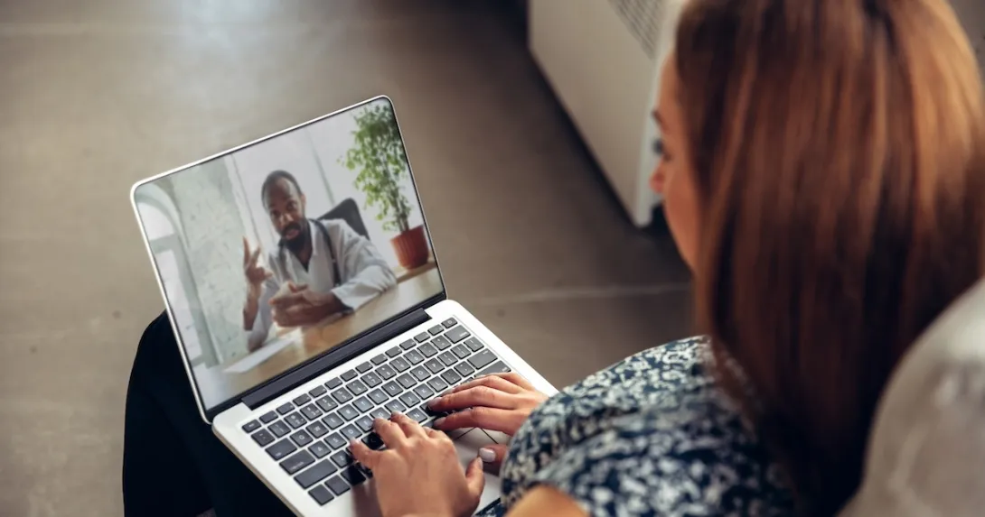 Patient interacting with healthcare professional via laptop