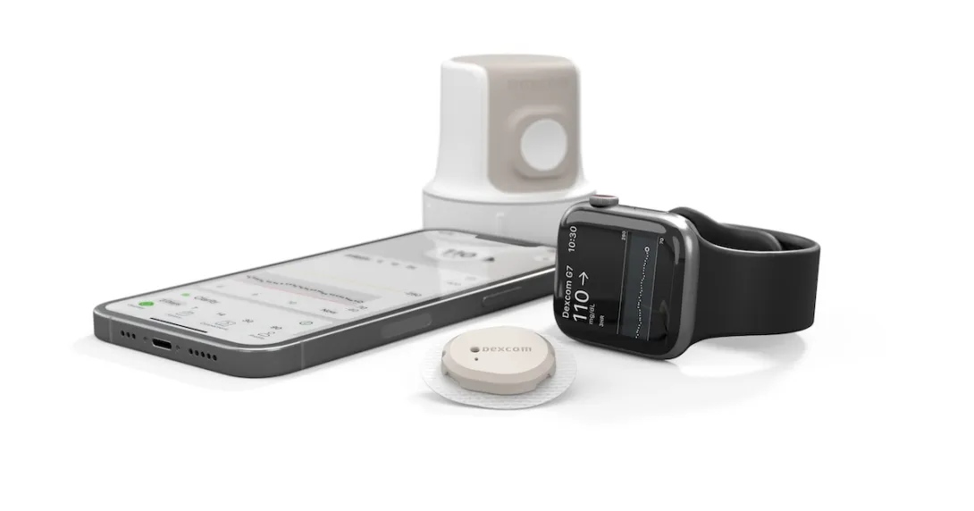 The Dexcom G7 alongside a smartphone and Apple Watch.