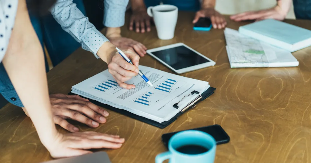 People standing around a table looking at a document