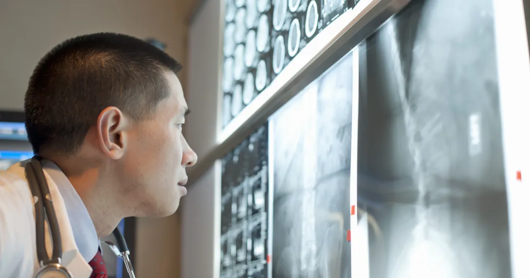 Healthcare provider looking at X-rays on a wall