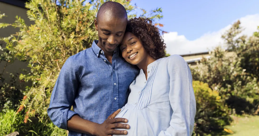 A man posing with a pregnant woman