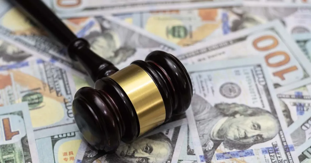 A gavel lying on a pile of money