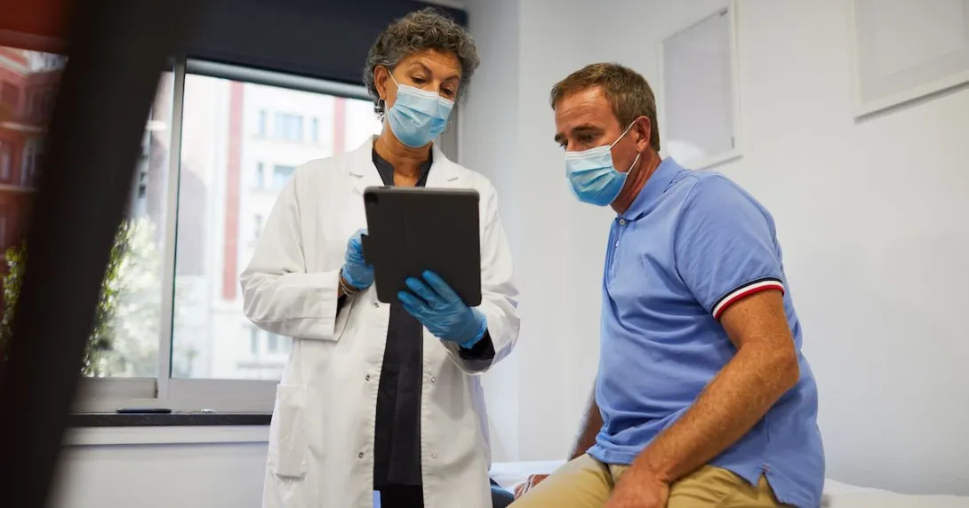 A medical professional showing a patient information on a tablet