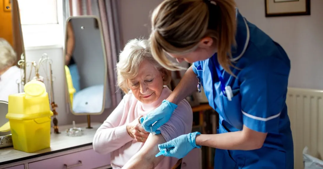 A nurse helping an older woman in her home