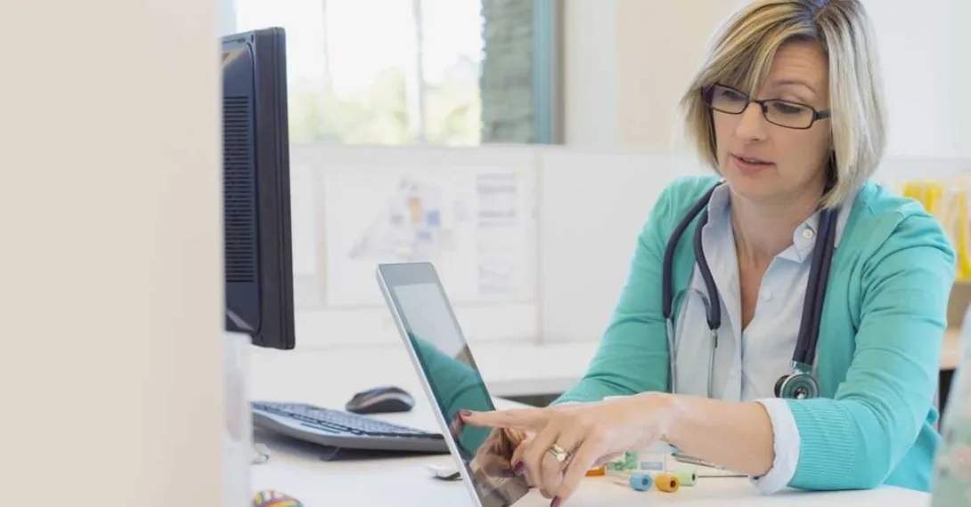 A doctor holding out a tablet.