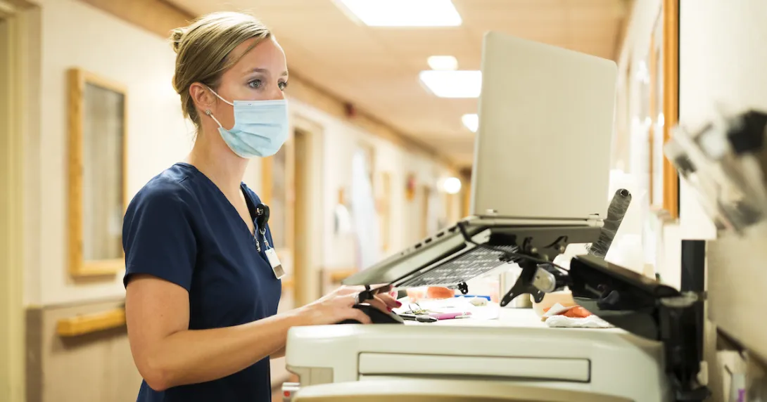 A nurse working at a computer in a hospital