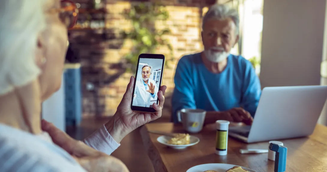 An older couple talking to a doctor via telehealth