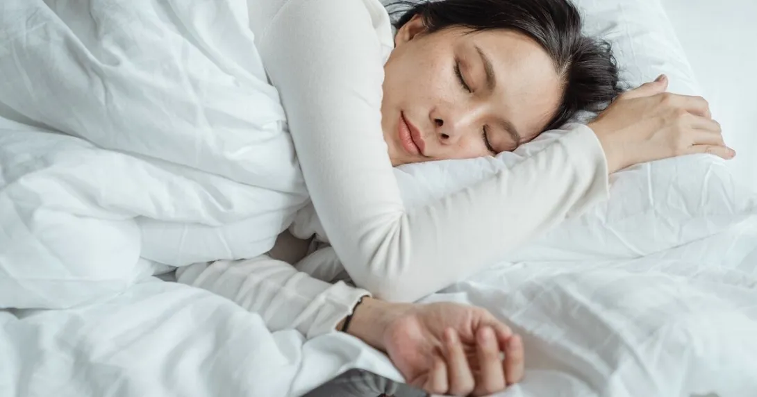 A person sleeping in bed with a smartphone on the side