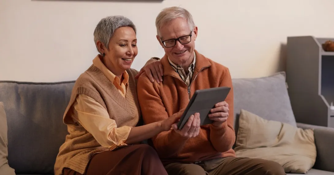 Two elderly persons using a tablet computer