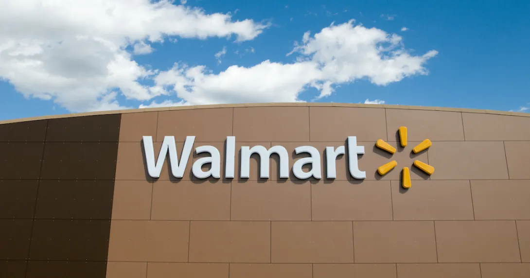 Walmart store front with the Walmart logo and the blue sky above the store