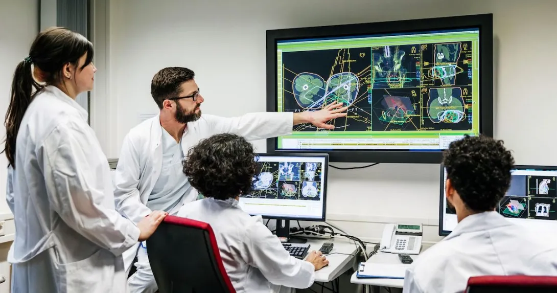 Healthcare providers sitting around a screen analyzing images