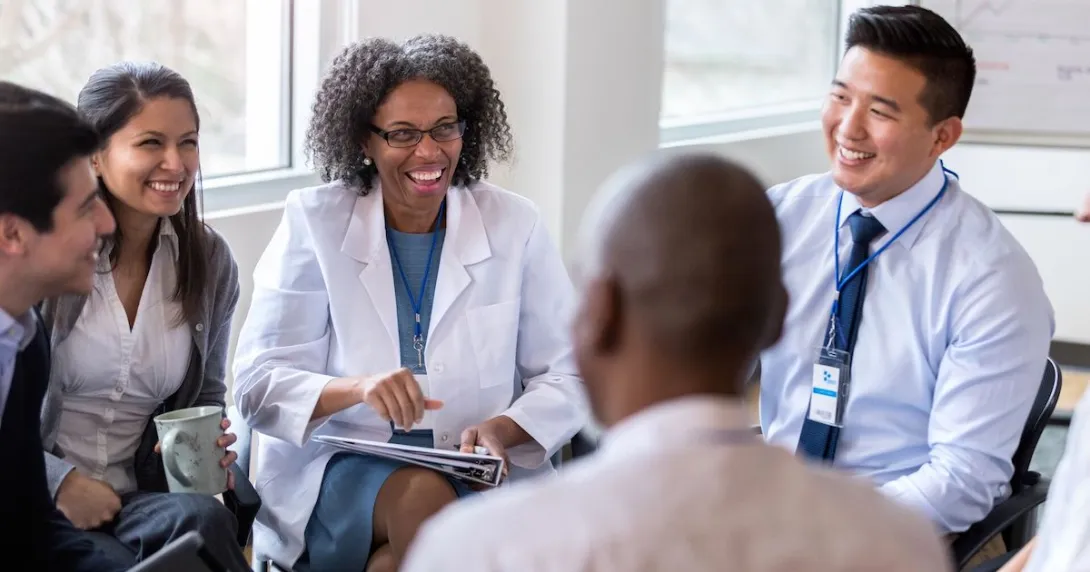 People sitting in a circle, looking at each other and smiling