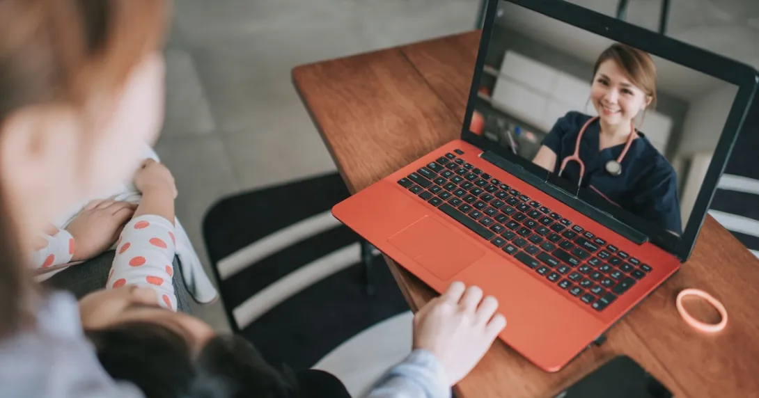 Telehealth provider on a computer with two people sitting on a couch looking at the computer