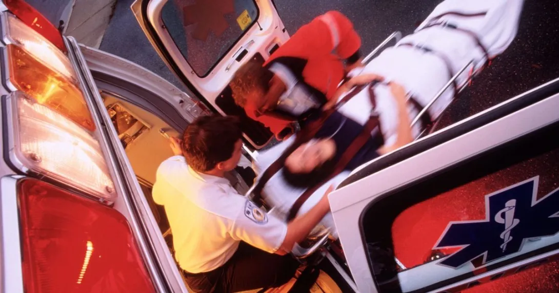 Responders move a patient on a stretcher inside the ambulance