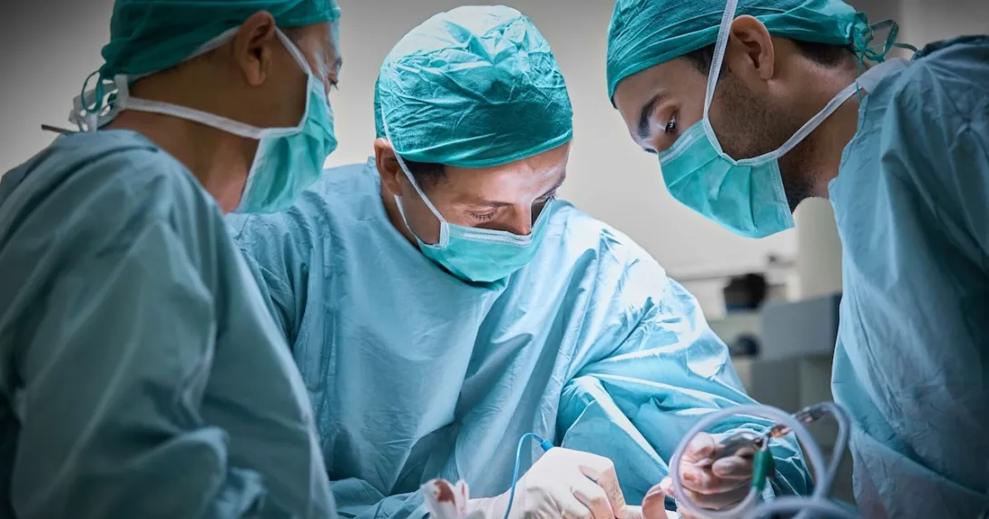 Three surgeons operating on a patient