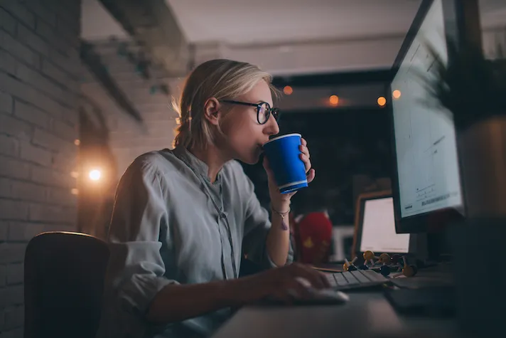A woman with coffee using her computer