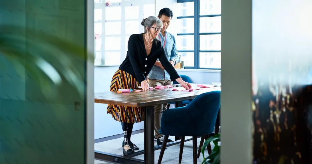 Two colleagues planning and brainstorming, using post its to organize ideas and plan